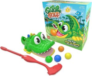 A green plastic gator with its mouth open, a flamingo-shaped golf club, and colorful golf balls scattered around.