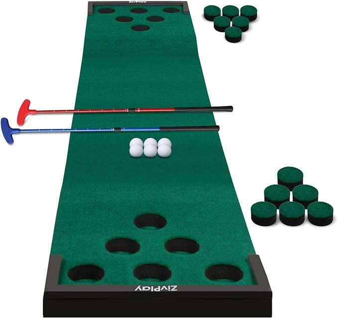 A green golf pong mat with six cups at each end, two putters, and several golf balls.