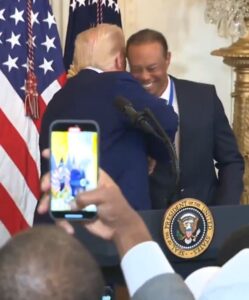 President Trump shakes Tiger Woods hand and hugs him