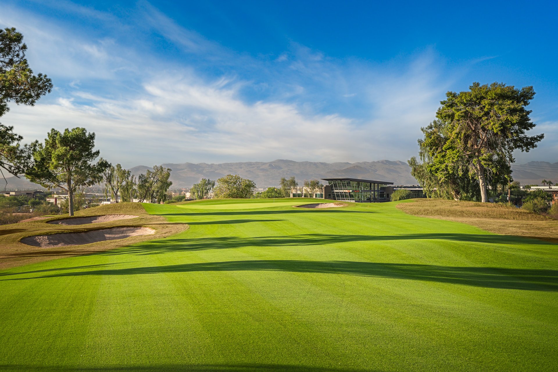 Papago Golf Club in Phoenix, Arizona: a winter-green fairway and bunkers with the Lou Grubb clubhouse and desert mountains behind the municipal course.