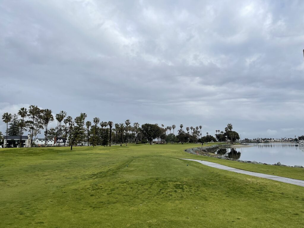 Fairway at Coronado Municipal Golf Course with palm trees and San Diego Bay along the right.