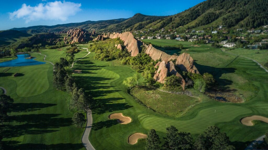 Aerial view of Arrowhead Golf Club in Littleton with red sandstone fins, green, and bunkers.