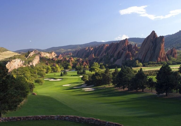 Arrowhead Golf Club fairway framed by red sandstone rock formations in Littleton, Colorado.