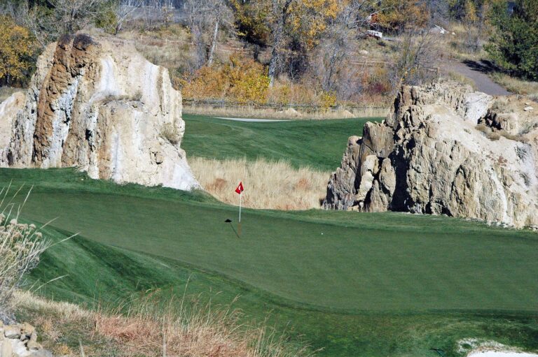 Putting green at Fossil Trace Golf Club in Golden, Colorado, framed by sandstone rock pillars.