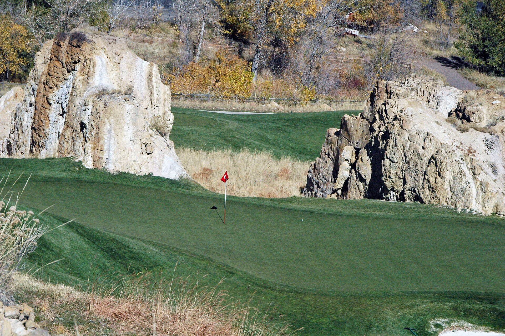 Putting green at Fossil Trace Golf Club in Golden, Colorado, framed by sandstone rock pillars.
