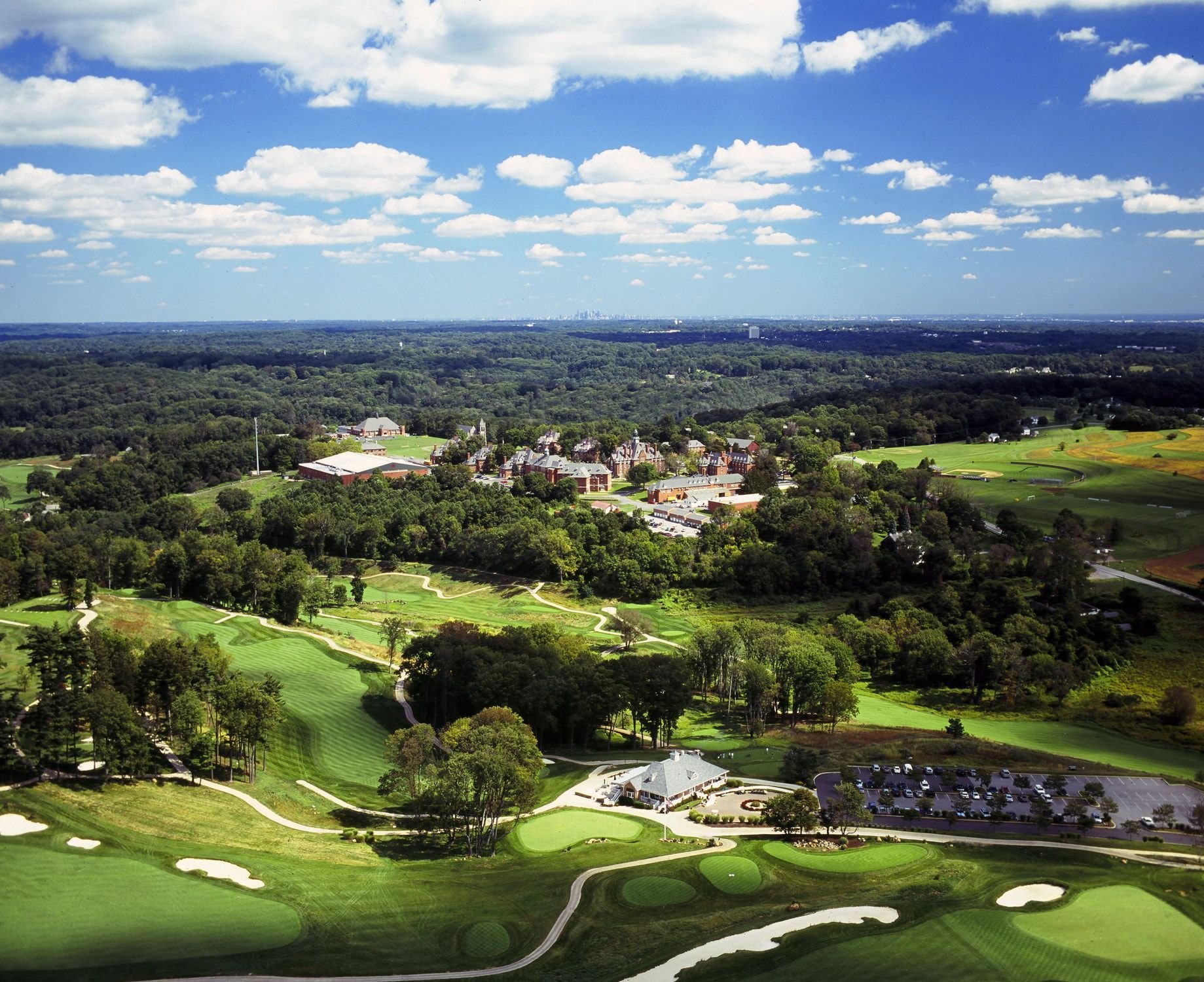 Aerial view of The Golf Course at Glen Mills with the Philadelphia skyline on the horizon