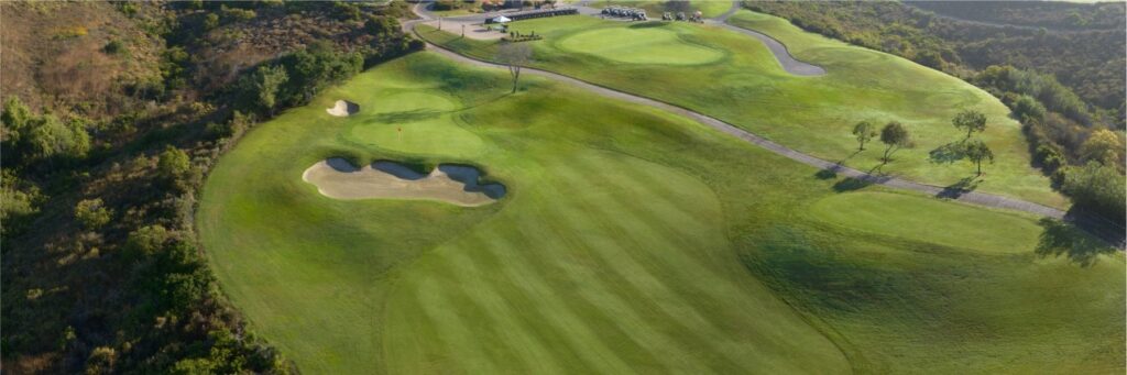 Aerial view of The Crossings at Carlsbad golf course fairways and bunkers in the coastal hills.
