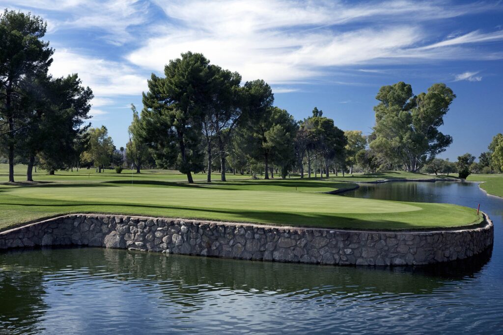 Randolph Golf Course green bordered by a stone wall and water in Tucson.