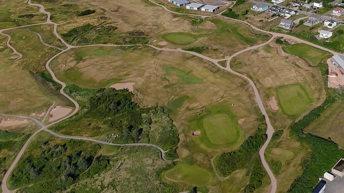 Aerial view of greens, bunkers and fescue on Cabot Links beside the town of Inverness, Nova Scotia