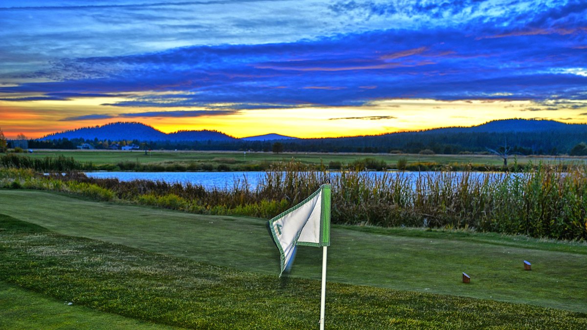 Flagstick on the Meadows course at Sunriver Resort with the Cascade foothills at sunset